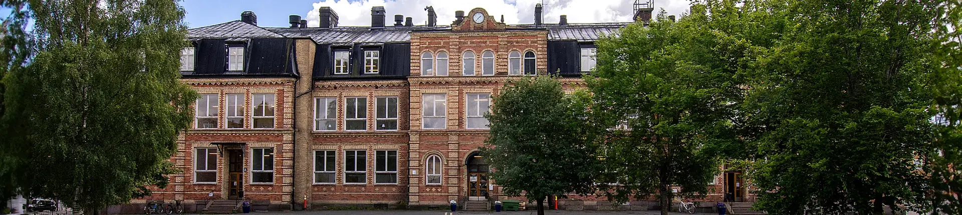 Nässjö lärcenters skolbyggnad i tegel och omgivande grönskande träd
