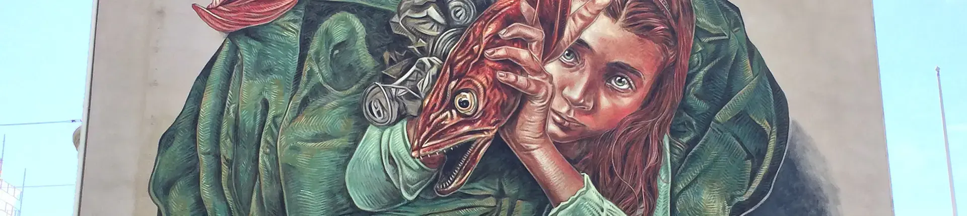 Väggmålning föreställande en flicka som håller i en stor röd fisk, omsluten av ett grönfärgat tyg. Konstverket täcker hela gaveln på en byggnad och är ett färgstarkt inslag i stadsmiljön.