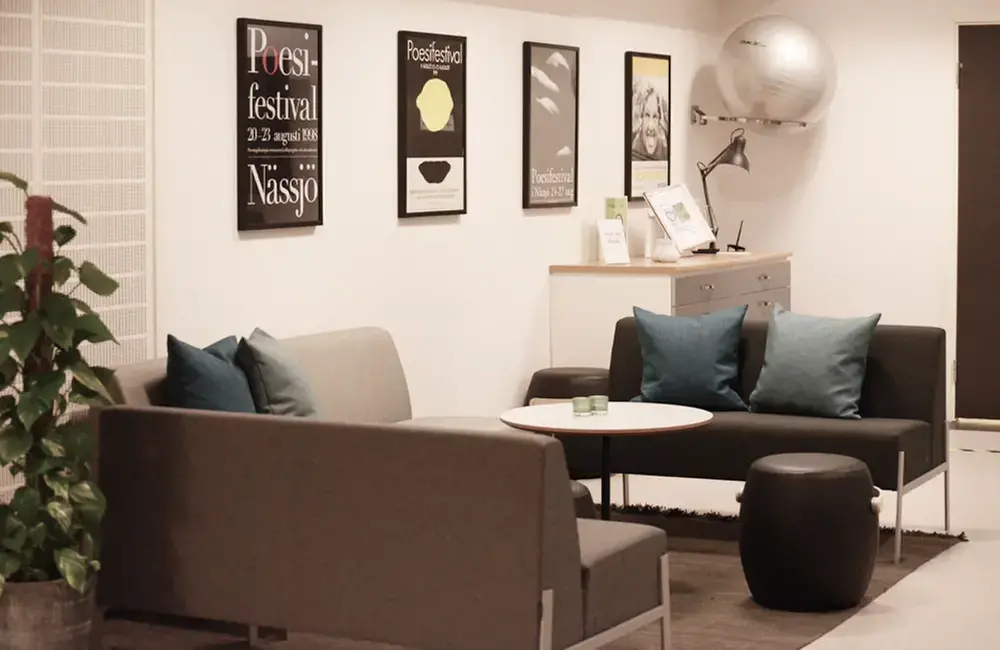 Interiör i ett rum som visar en soffgrupp och tavlor på väggen.