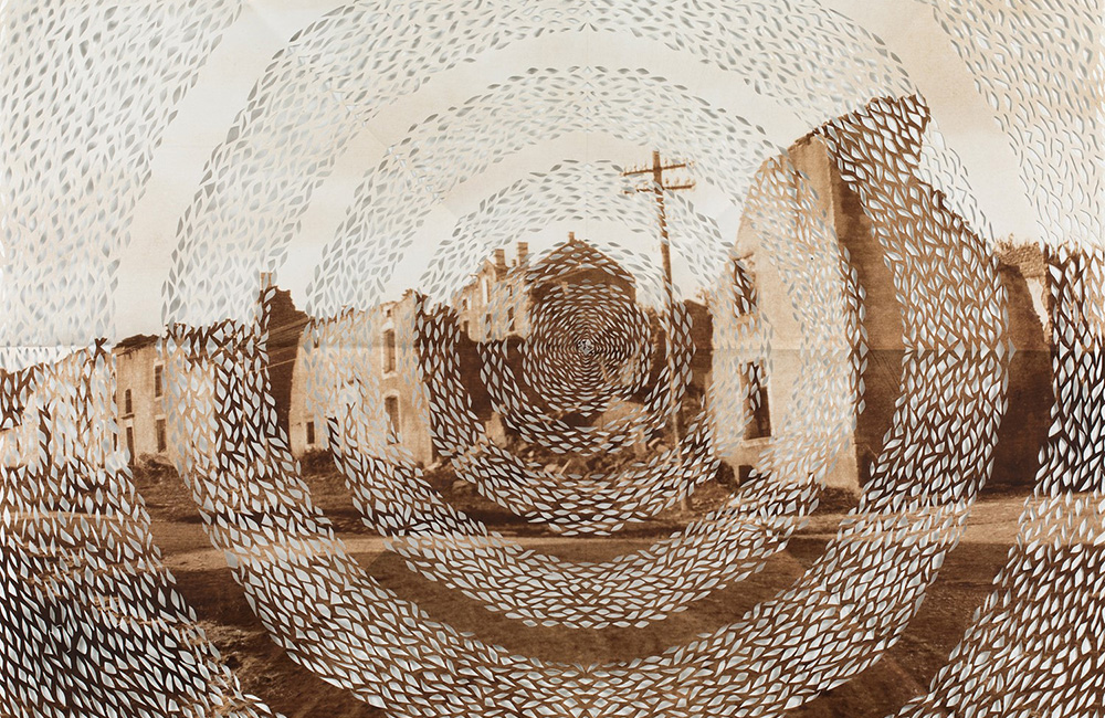 Ett gammalt sepiatonat foto av en stad i ruiner där ett mönster skurits ut i koncentriska cirklar 